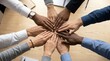 © alex - Top view of diverse business team stacking hands together in unity over wooden desk