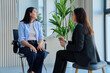© Valerii Honcharuk - Young woman talking to female psychologist during therapy session in office