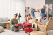 © Pixel-Shot - Family christmas celebration, multi-generational family opening presents together in a cozy living room during the winter holiday season