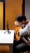 © Aliaksandr - Young guitarist, sitting beside an empty smartphone tripod, covering his face with both hands while holding an acoustic guitar, conveying creative frustration and emotional exhaustion at home
