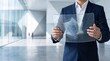 © Hao - Businessman holding futuristic transparent holographic tablet displaying geometric data cube interface, modern office technology presentation