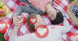 © vectorfusionart - Image of hearts and like icons over caucasian female couple having picnic