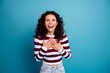© deagreez - Happy young woman expressing surprise and gratitude with hands on chest against blue background