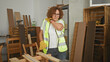 © Krakenimages.com - Woman carpenter rubbing shoulder while standing by wooden planks in a building; fatigue resilience craft.
