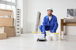 © Pixel-Shot - Home renovation and interior painting, professional painter in uniform with tools preparing for wall refurbishment in a new apartment or office space