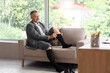 © Pixel-Shot - Compression therapy and venous health, mature businessman putting on medical compression socks for circulation support and leg swelling relief in office