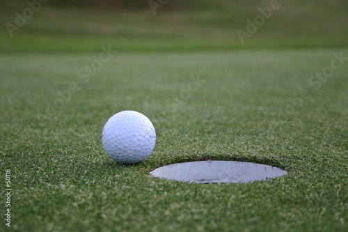 balle de golf devant un trou