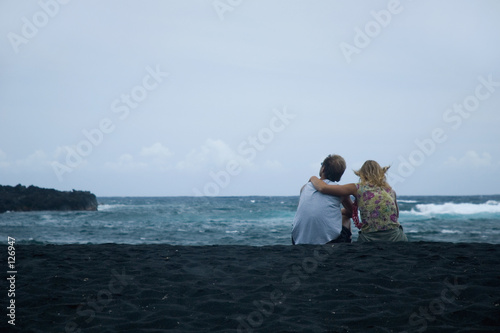 couple sitting on the sand © cameraman