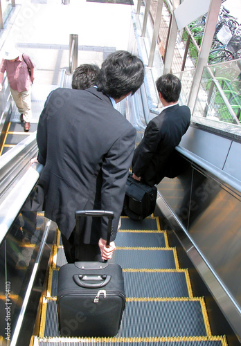 businessmen on moving staircase photo