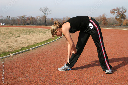athletic young woman stretching at the track © Ixepop
