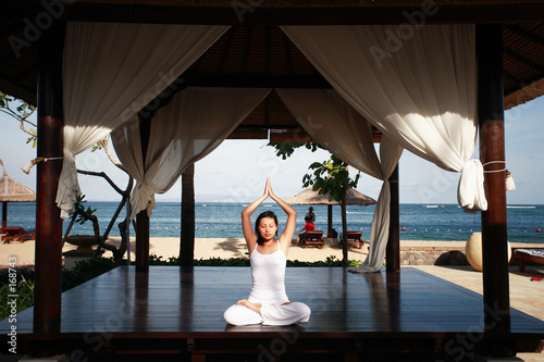 asian woman meditating by the beach photo