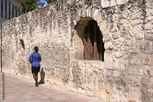 Foto business woman walking by the alamo