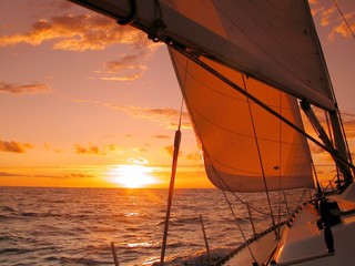 Fotobehang Zeilen Zeilboot koers richting oranje zonsondergang  © João Freitas