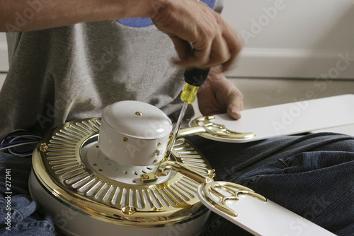 hands assembling a ceiling fan