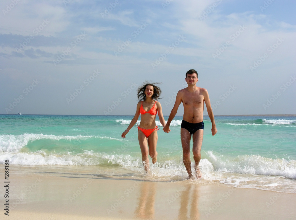 couple walk from ocean