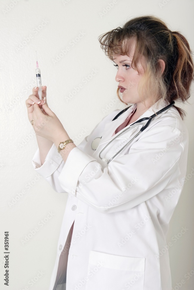 lady doctor prepping up a syringe lady doctor prepping up a syringe