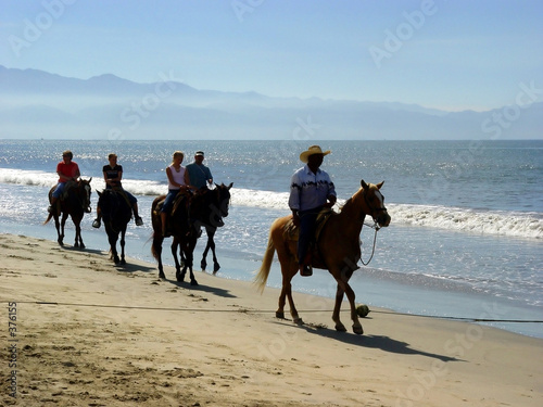 horseback riders at the beach photo