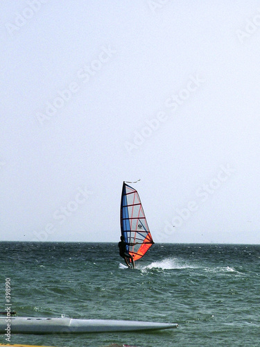 Windsurfista en el agua con otra tabla de surf en primer plano