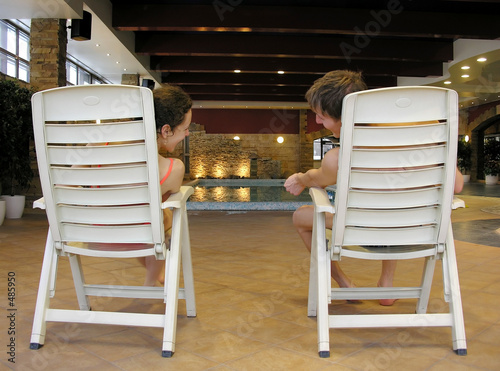 behind couple on chairs and swimming pool photo