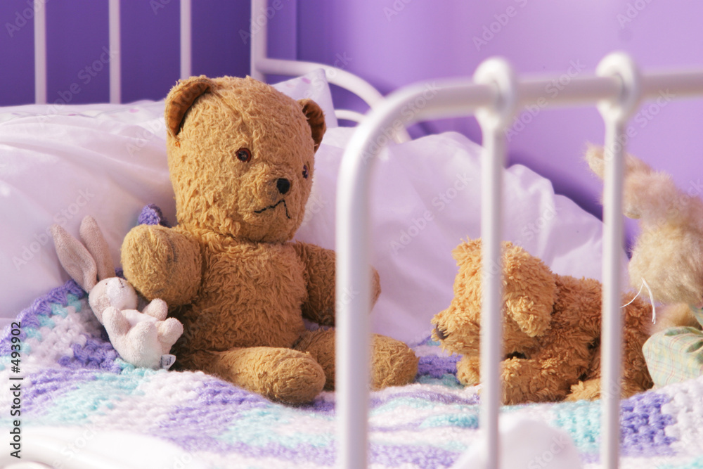 Fotografie scruffy old teddy bears on a child's bed
