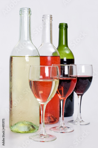 bottles of red, white and rose wine with glasses