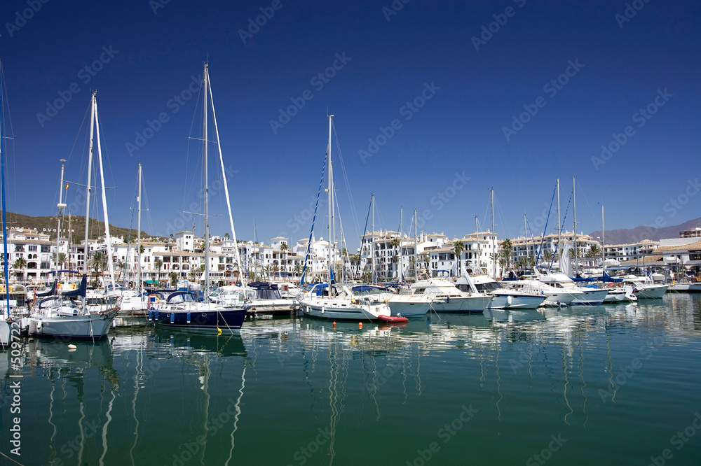 tall luxury boats and yachts moored in duquesa port in spain on