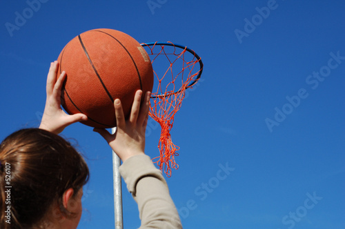 young girl taking aim with a basketball