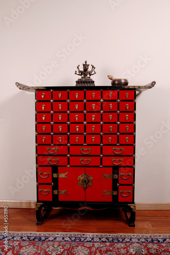 a lamaist diety figurine, prayer bowl and a medicine cabinet