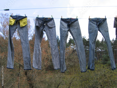 Fotografie Quatre pantalons en jean sèchent sur un étendage
