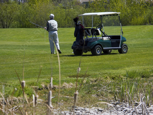golfer on golf course with golf cart