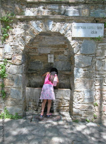 a girl drinks at the spring of meryemana (virgin m