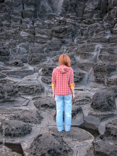 woman standing on volcanic rock