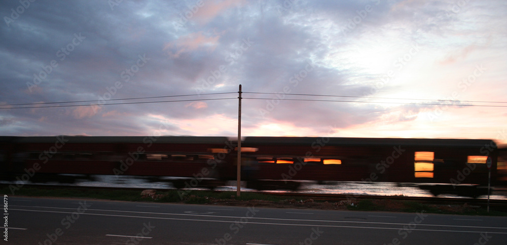 a train speeding away - sunset on the background