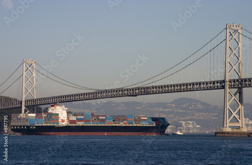 container ship under bridge