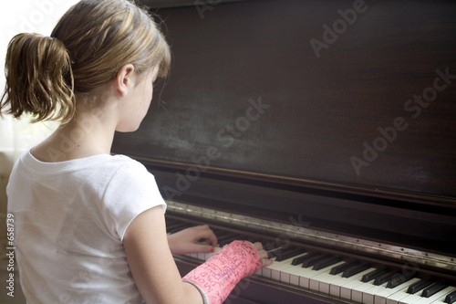 girl with broken arm plays piano