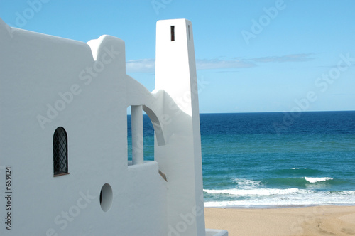 house on the beach with blue sky in the background