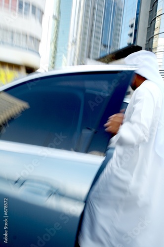men wearing disdasha and entering his car