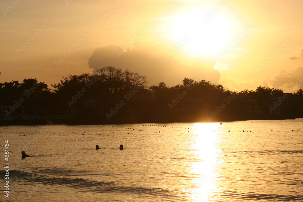 beautiful sunset over people swimming in the water beautiful sunset over people swimming in the water