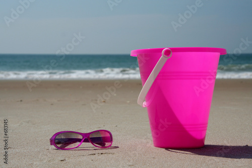 sun glasses and pail at the beach