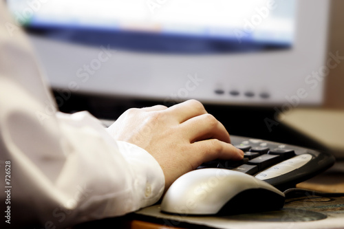 hand typing at a computer