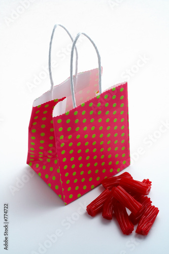 red shopping bag and pieces of red licorices photo