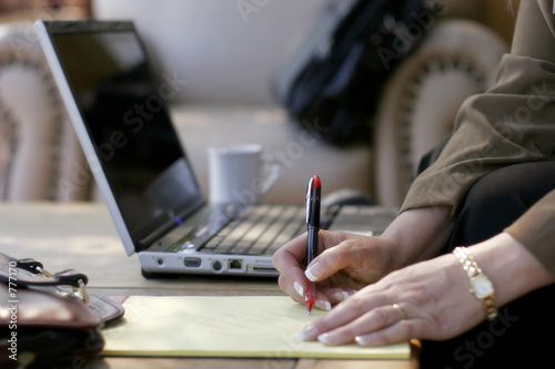 businesswoman writing notes at computer