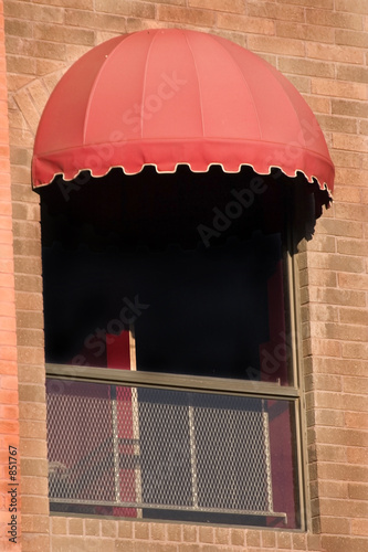 brick wall and a window with red awning