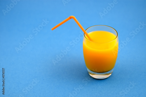 glass of orange juice with cockteil straw photo