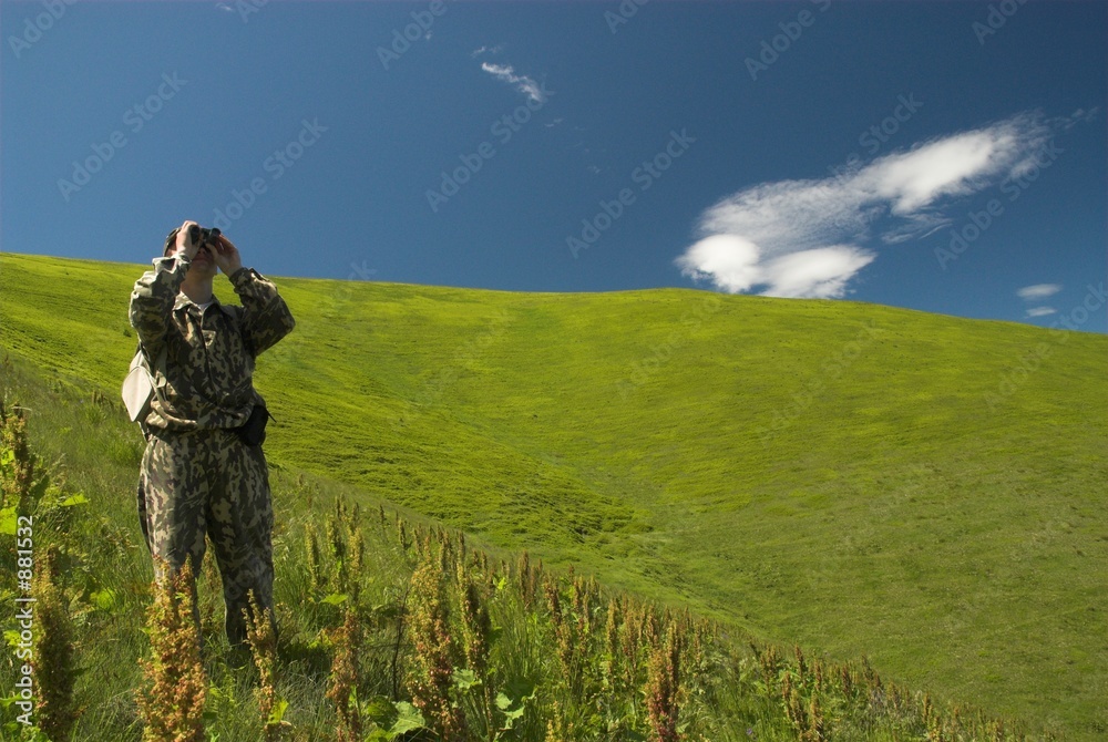 man with binoculars in the mountains