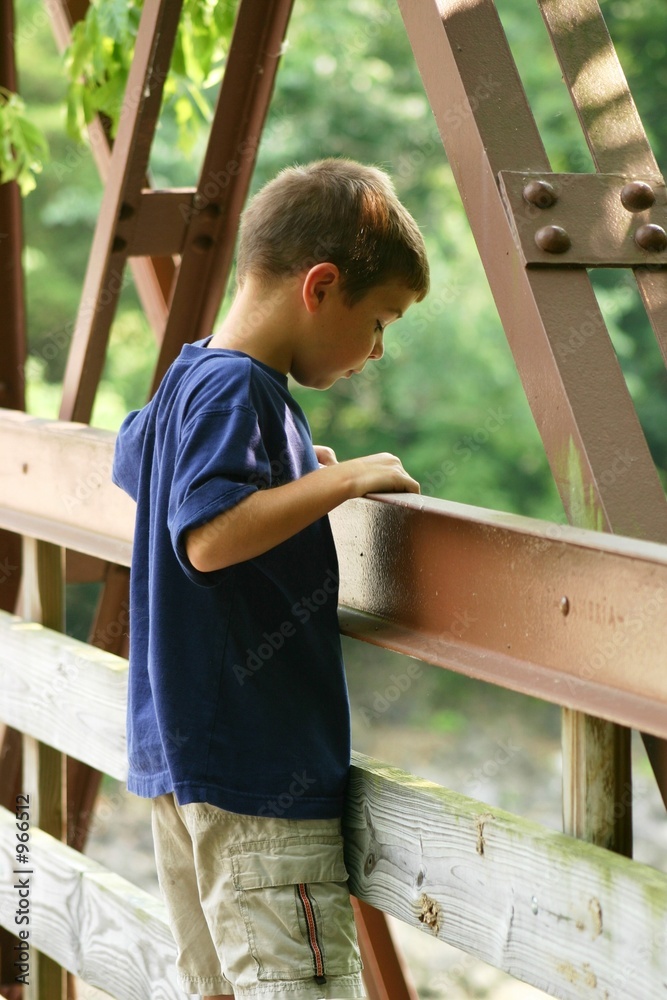 boy looking over bridge boy looking over bridge
