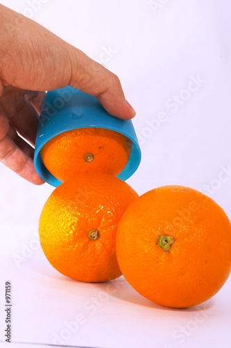 three oranges with bright blue cup photo