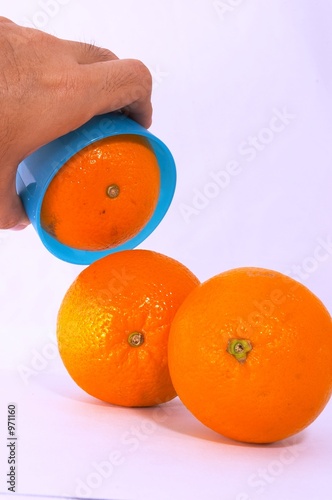 three oranges with bright blue cup photo