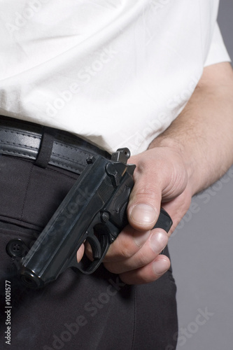 man a hiding pistol behind a back