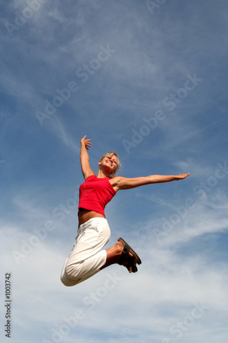 happy woman jumping against blue sky
